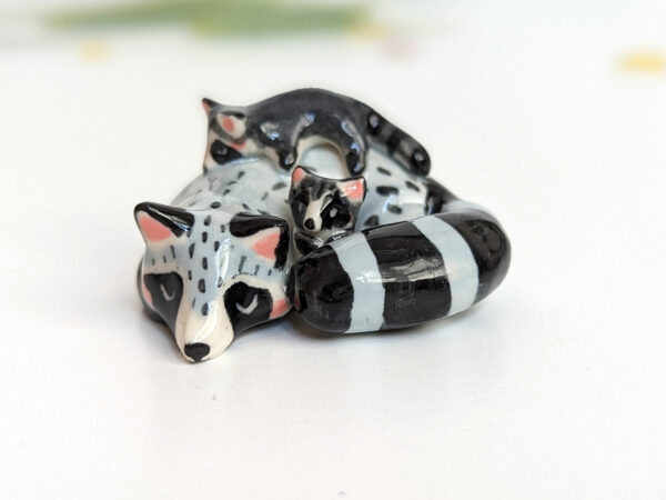 adorable porcelain figurine of a raccoon family sleeping collectible