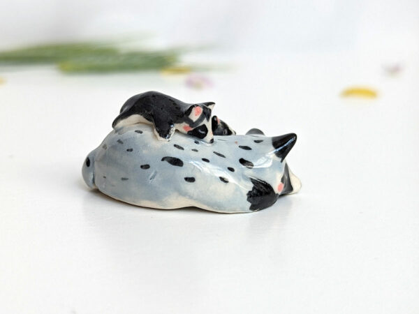 adorable porcelain figurine of a raccoon family sleeping collectible