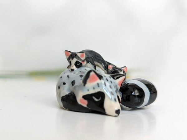 adorable porcelain figurine of a raccoon family sleeping collectible