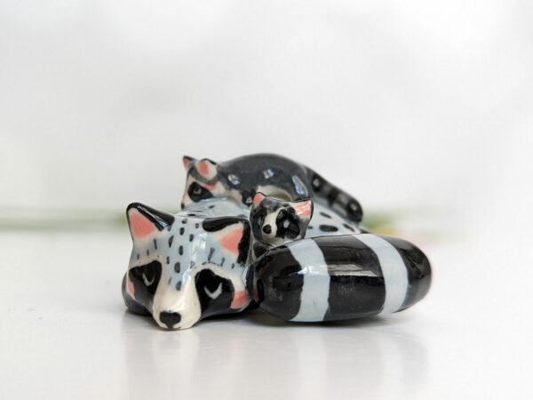adorable porcelain figurine of a raccoon family sleeping collectible