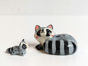 adorable porcelain figurine of a raccoon family sleeping collectible