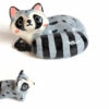 adorable porcelain figurine of a raccoon family sleeping collectible