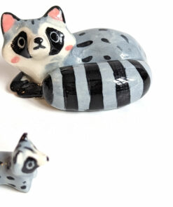 adorable porcelain figurine of a raccoon family sleeping collectible