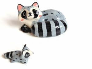 adorable porcelain figurine of a raccoon family sleeping collectible