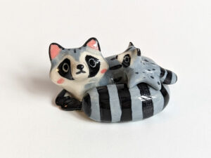 adorable porcelain figurine of a raccoon family sleeping collectible