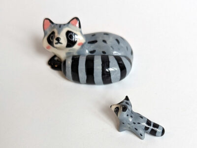 adorable porcelain figurine of a raccoon family sleeping collectible