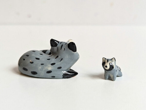 adorable porcelain figurine of a raccoon family sleeping collectible