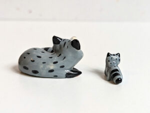 adorable porcelain figurine of a raccoon family sleeping collectible