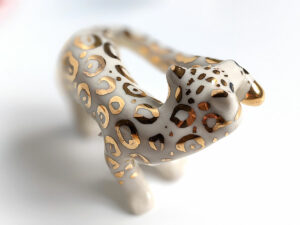 snow leopard munching tail porcelain figurine