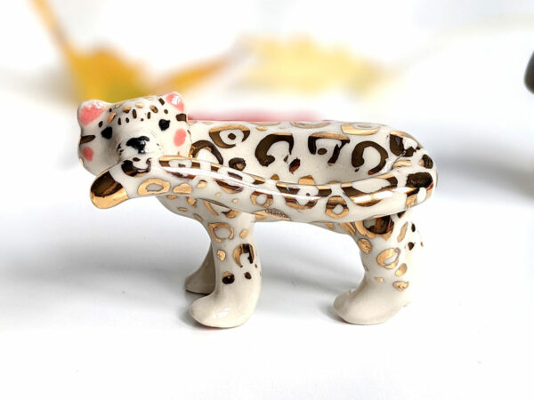 snow leopard munching tail porcelain figurine