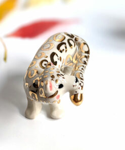 snow leopard munching tail porcelain figurine