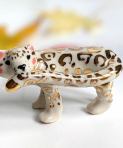 snow leopard munching tail porcelain figurine