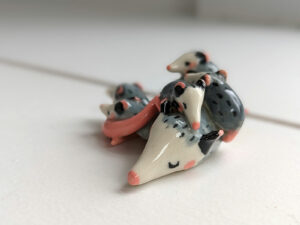 extremely cute opossum mama figurine sleeping with babies - kness