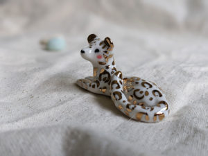 gold and porcelain snow leopard figurine