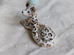 gold and porcelain snow leopard figurine