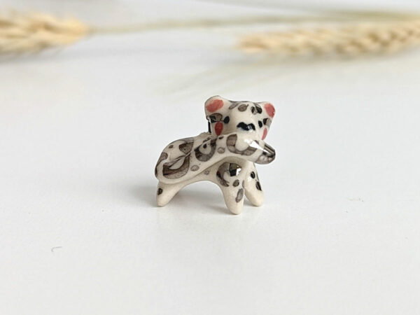 snow leopard tail eating pendant porcelain kness