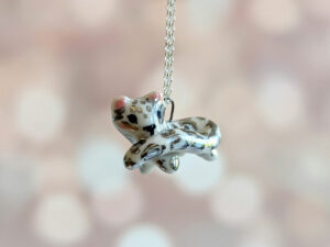 snow leopard tail eating pendant porcelain kness