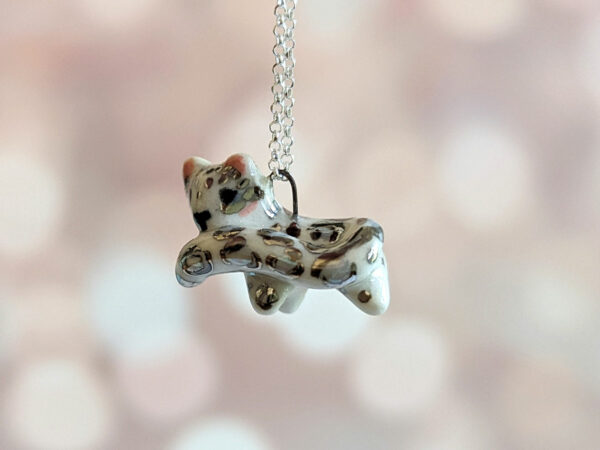snow leopard tail eating pendant porcelain kness