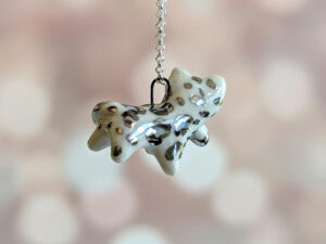 snow leopard tail eating pendant porcelain kness