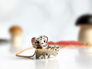 snow leopard tail eating pendant porcelain kness