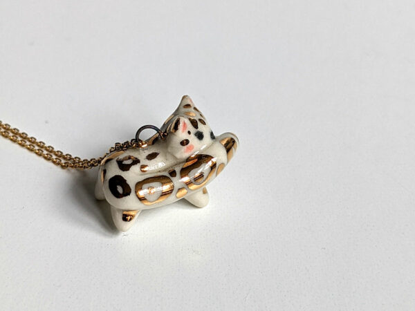 snow leopard tail eating pendant porcelain kness
