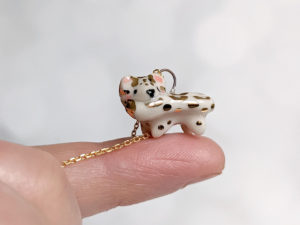porcelain pendant snow leopard biting tail