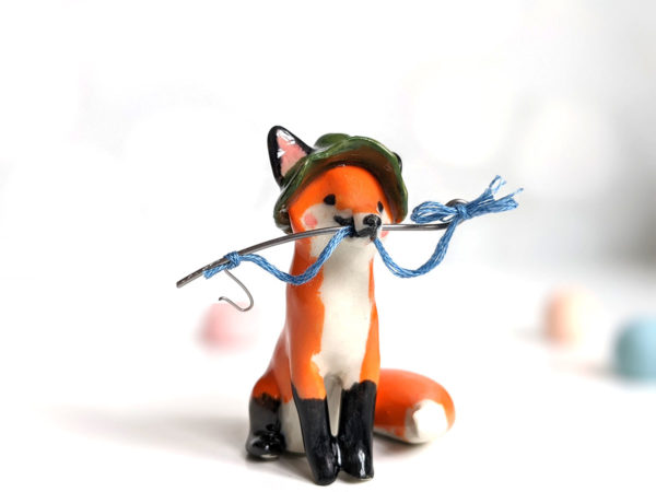 Fox figurine with fishing gear