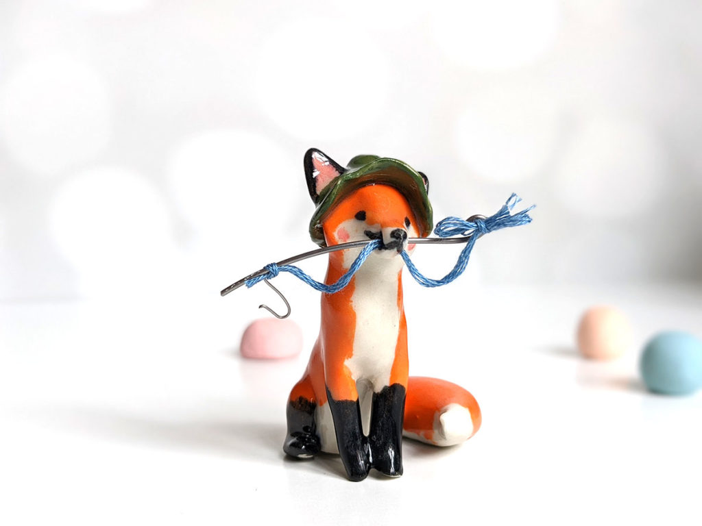 Fox figurine with fishing gear