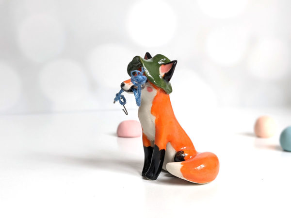 Fox figurine with fishing gear