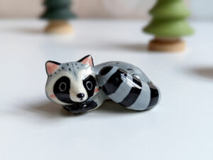 sleepy raccoon porcelain figurine