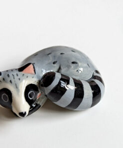 sleepy raccoon porcelain figurine