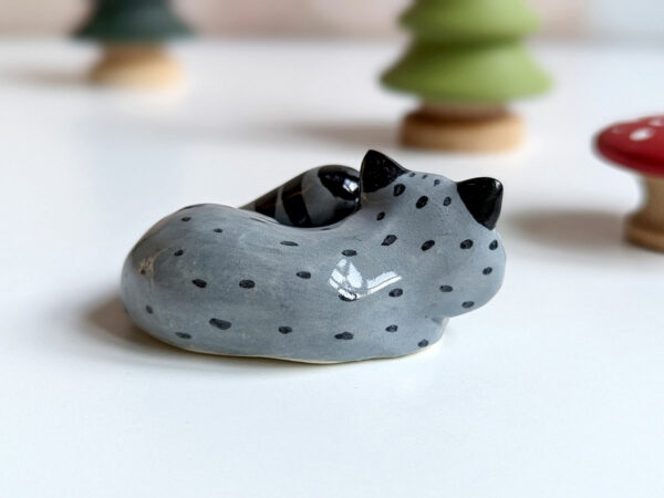 sleepy raccoon porcelain figurine