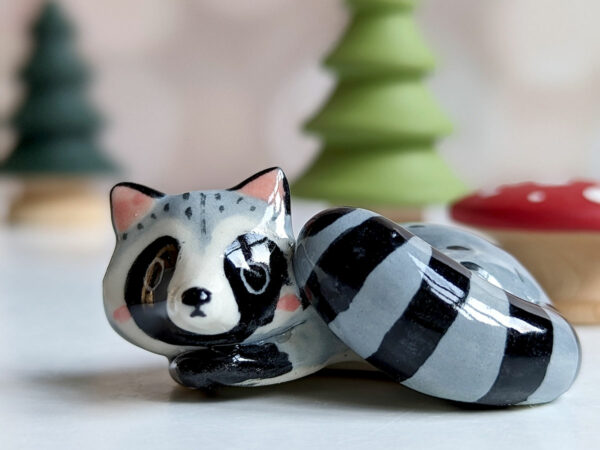 sleepy raccoon porcelain figurine