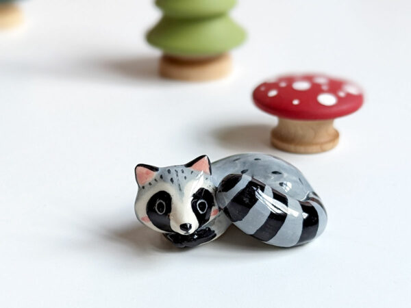 sleepy raccoon porcelain figurine