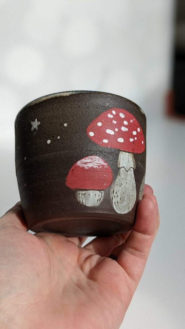 black clay cup with cute hedgehog and mushroom