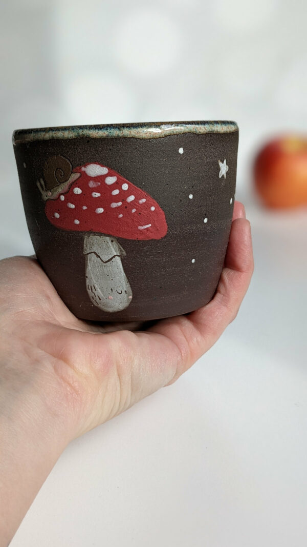 black clay cup with cute hedgehog and mushroom