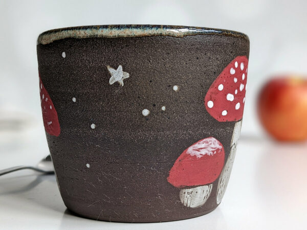 black clay cup with cute hedgehog and mushroom