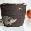 black clay cup with cute hedgehog and mushroom