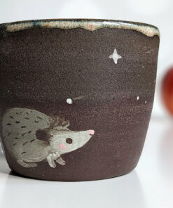 black clay cup with cute hedgehog and mushroom