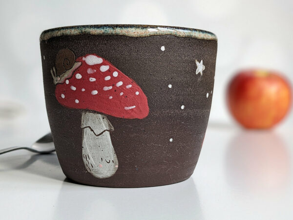 black clay cup with cute hedgehog and mushroom