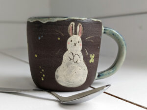 black stoneware mug with bunnies