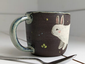 black stoneware mug with bunnies