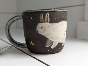 black stoneware mug with bunnies
