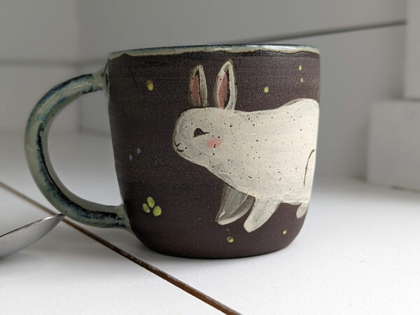 black stoneware mug with bunnies