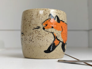 cute cup in speckled clay illustrated with fox and hare - kness