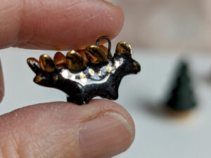 shiny black stegosaurus pendant with gold