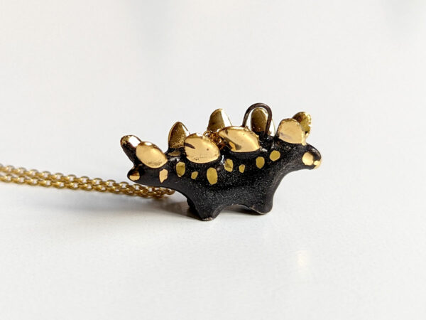 shiny black stegosaurus pendant with gold