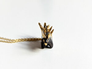 shiny black stegosaurus pendant with gold