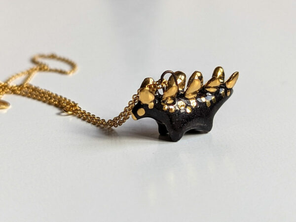 shiny black stegosaurus pendant with gold