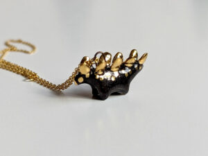 shiny black stegosaurus pendant with gold